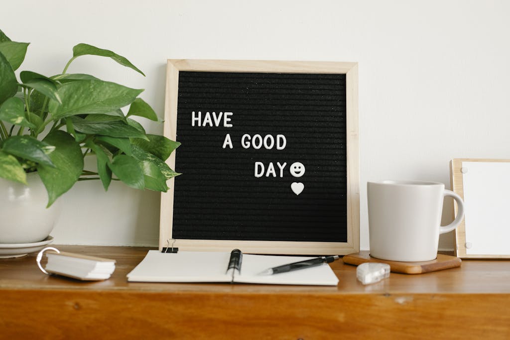 Stylish workspace with motivational board, plant, and coffee cup for a fresh morning start.